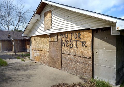 A damaged home remains boarded up in a hard-hit neighborhood.
