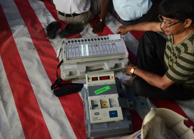 An election official checks an electronic voting machine before taking it to polling stations at a distribution center in Siliguri, India, on Wednesday, April 16. 