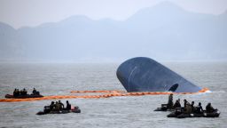 Coast guard members search for passengers near a South Korean ferry (C) that capsized on its way to Jeju island from Incheon, at sea some 20 kilometres off the island of Byungpoong in Jindo on April 17, 2014.  South Korean rescue teams, including elite navy SEAL divers, raced to find up to 293 people missing from a capsized ferry carrying 459 passengers and crew -- mostly high school students bound for a holiday island. AFP PHOTO   AFP PHOTO / ED JONES        (Photo credit should read ED JONES/AFP/Getty Images)