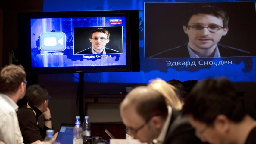 Edward Snowden, displayed on television screens, asks a question to Russian President Vladimir Putin during a nationally televised question-and-answer session, in Moscow, Thursday, April 17, 2014.  Speaking in a televised call-in show with the nation, Putin harshly criticized the West for trying to pull Ukraine into its orbit and said that people in eastern Ukraine have risen against the authorities in Kiev, who ignored their rights and legitimate demands. Putin also took a video question from National Security Agency leaker Edward Snowden, whom Russia granted asylum last year. Asked by Snowden about Russia's surveillance programs, Putin said that Russian special services also tap on communications in their fight against terrorism, but don't do it on such a massive scale as the U.S. (AP Photo/Pavel Golovkin)