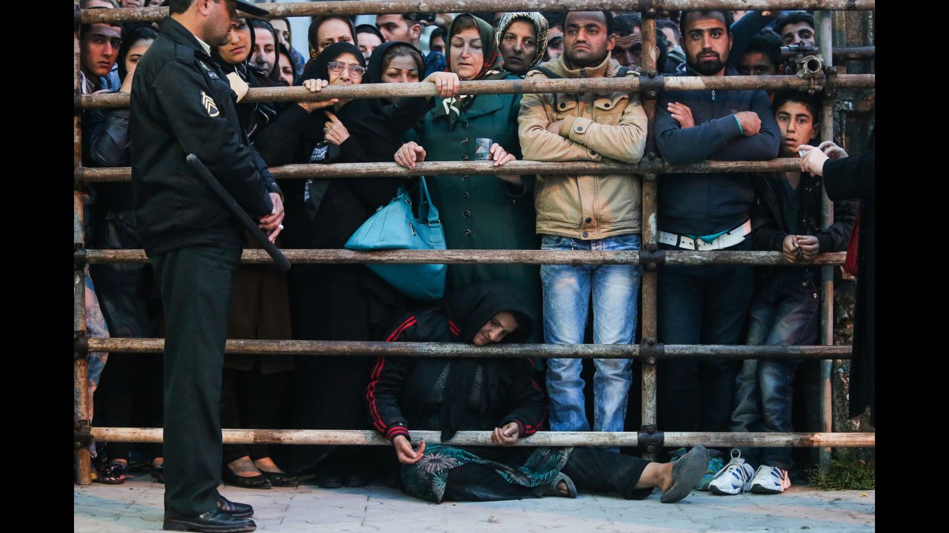 Koukab sits on the ground amongst the crowd before her son was brought out from the prison.