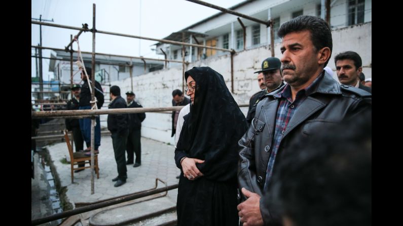 Maryam and Abdulghani Hosseinzadeh, the victim's parents, stand next to the execution platform as Balal is prepared to be hanged.