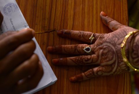 An Indian election official marks the finger of a voter with ink before she casts her ballot in Sambhar, India, on April 17.