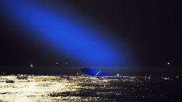 A blue search light cast by a South Korean Coast Guard helicopter illuminates the ferry on April 17 as search and rescue operations continue.