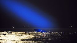 A blue search light cast by a South Korean Coast Guard helicopter illuminates the ferry on April 17 as search and rescue operations continue.