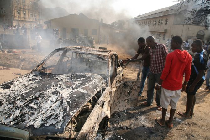 Men look at the wreckage of a car after a bomb blast at St. Theresa Catholic Church outside Abuja on December 25, 2011. A string of bombs struck churches in five Nigerian cities,<a href="index.php?page=&url=http%3A%2F%2Fwww.cnn.com%2F2011%2F12%2F25%2Fworld%2Fafrica%2Fnigeria-church-bombing%2Findex.html"> leaving dozens dead and wounded on the Christmas holiday</a>, authorities and witnesses said. Boko Haram's targets included police outposts and churches as well as places associated with "Western influence."
