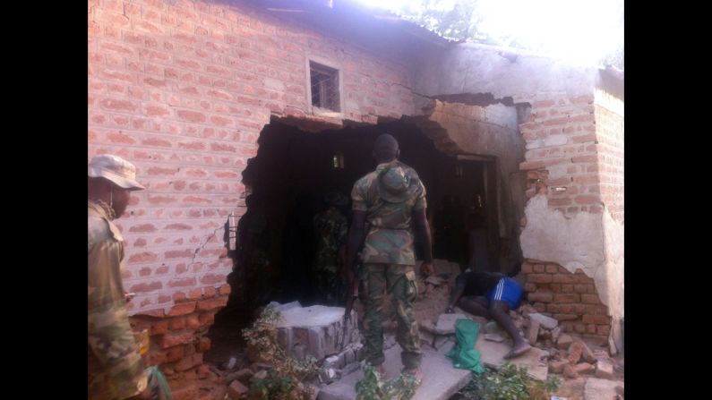 A soldier stands in front of a damaged wall and the body of a prison officer killed during an attack on a prison in the northeastern Nigerian town of Bama on May 7, 2013. Two soldiers were killed <a href="index.php?page=&url=http%3A%2F%2Fedition.cnn.com%2F2013%2F05%2F09%2Fworld%2Fafrica%2Fnigeria-violence%2Findex.html">during coordinated attacks on multiple targets</a>. Nigeria's military said more than 100 Boko Haram militants carried out the attack. 