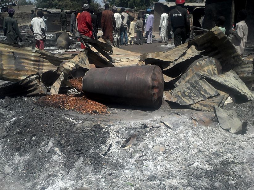 Police officers stand guard in front of the burned remains of homes and businesses in the village of Konduga on February 12, 2014. Suspected Boko Haram militants<a href="http://edition.cnn.com/2014/02/12/world/africa/nigeria-unrest/"> torched houses in the village,</a> killing at least 23 people, according to the governor of Borno state on February 11.