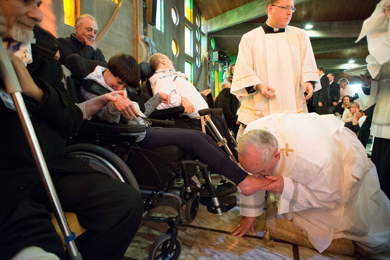 Pope Francis kisses the foot of a woman in Rome on Thursday, April 17. 
