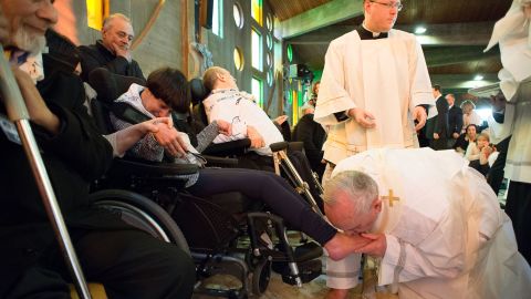 Pope Francis kisses the foot of a woman in Rome on Thursday, April 17.