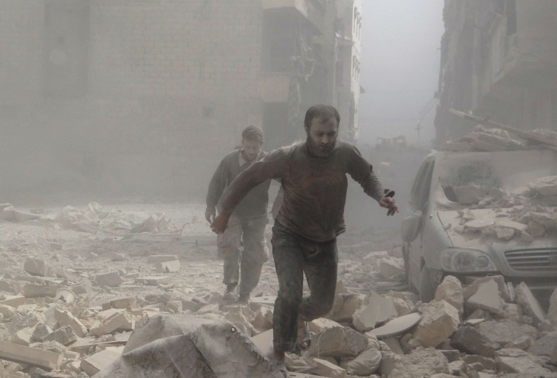 Syrians walk in rubble after clashes in Aleppo, Syria, on Saturday, April 12.