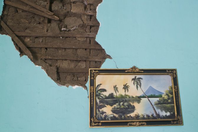 A painting of a Nicaraguan lake hangs from a damaged wall Friday, April 11, inside a home that was damaged a day earlier by an earthquake in Nagarote, Nicaragua.