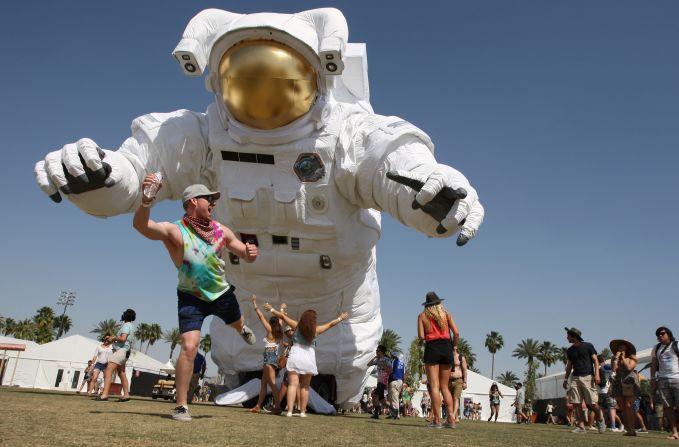 A man poses for friends in front of a giant inflated astronaut Saturday, April 12, at the <a href="http://www.cnn.com/2014/04/14/showbiz/gallery/coachella-festival/index.html">Coachella Valley Music and Arts Festival</a> in Indio, California.
