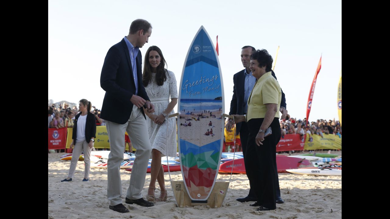 William and Catherine receive a surfboard alongside Australian Prime Minister Tony Abbott and Manly Mayor Jean Hay at Manly Beach.