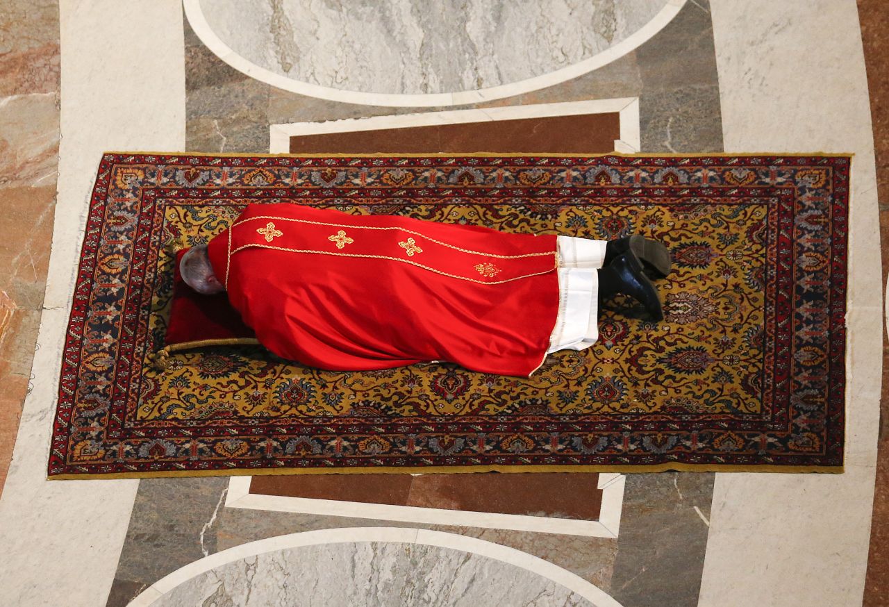 Pope Francis lies on the floor in prayer before presiding over a Good Friday service in St. Peter's Basilica.