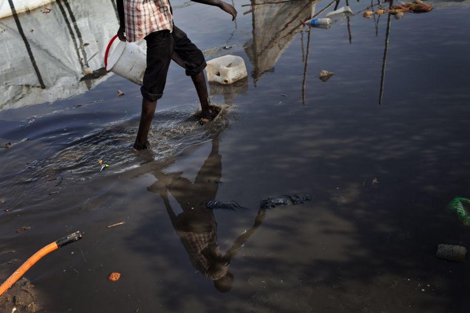 A South Sudanese man walks in a puddle Saturday, March 15, at a camp for internally displaced people.
