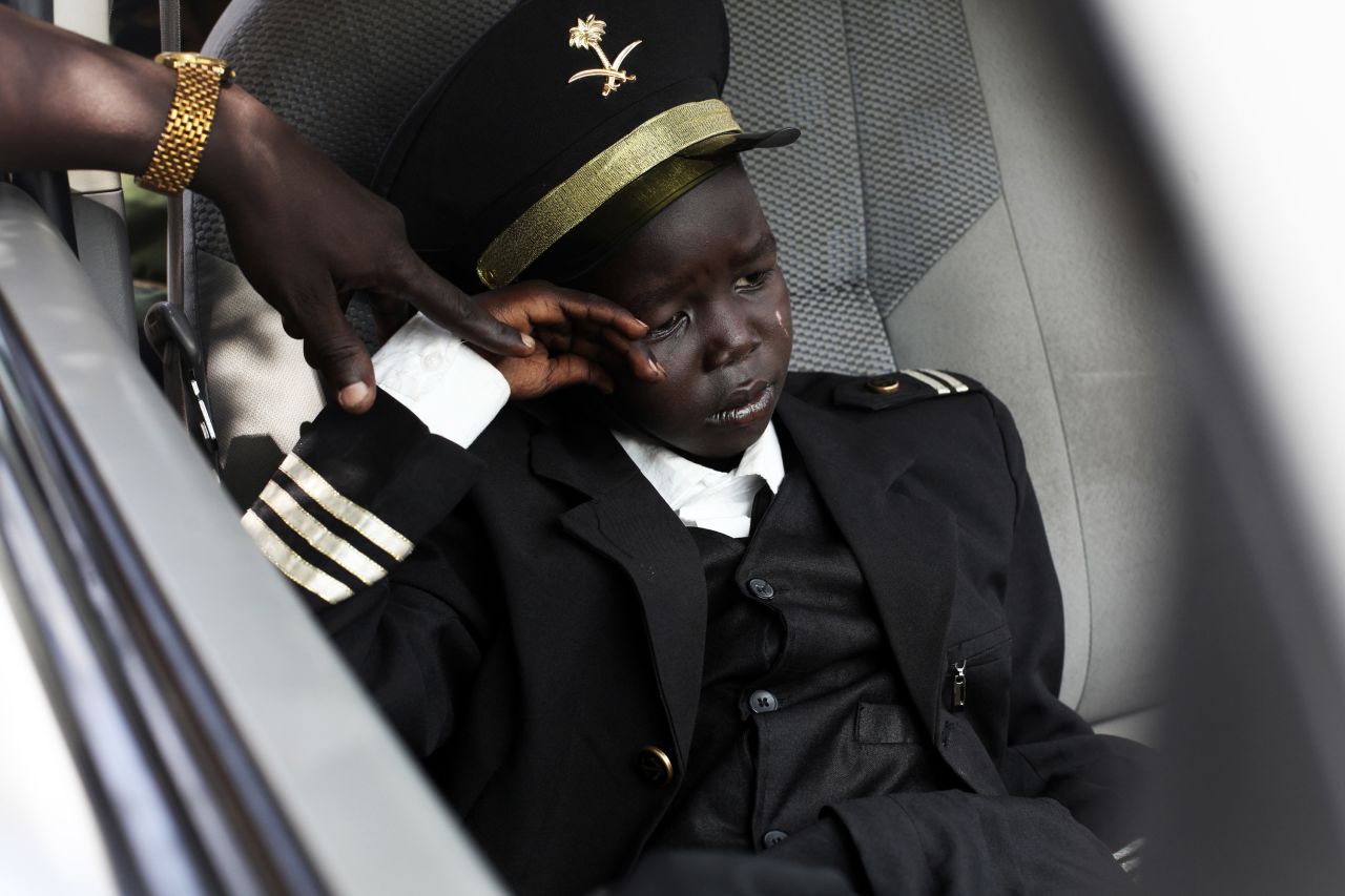 An 8-year-old boy waits in a car during Petroleum Minister Stephen Dhieu Dau's visit to an oil production facility in Paloch, South Sudan, on Sunday, March 2. The boy's father, a member of the Sudan People's Liberation Army, said his son was dressed like a pilot because that's what he wants to be when he grows up.