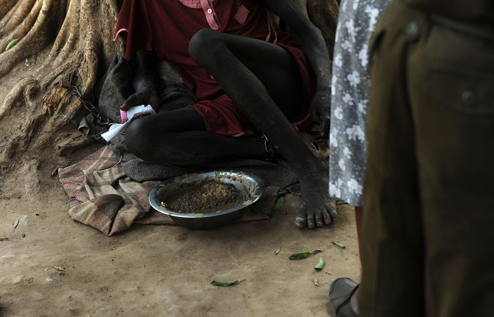 An inmate sits shackled to a tree Wednesday, February 19, in the courtyard of the central prison in Rumbek, South Sudan.