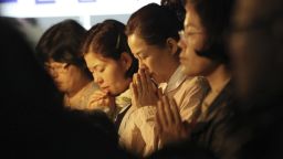Relatives of missing passengers aboard the sunken ferry Sewol pray to wish for safe return of their family members during an annual Easter service in Jindo, South Korea, Sunday, April 20, 2014. After more than three days of frustration and failure, divers on Sunday finally found a way into the submerged ferry off South Korea's southern shore, discovering more than a dozen bodies inside the ship and pushing the confirmed death toll to over four dozens, officials said. (AP Photo/Ahn Young-joon)