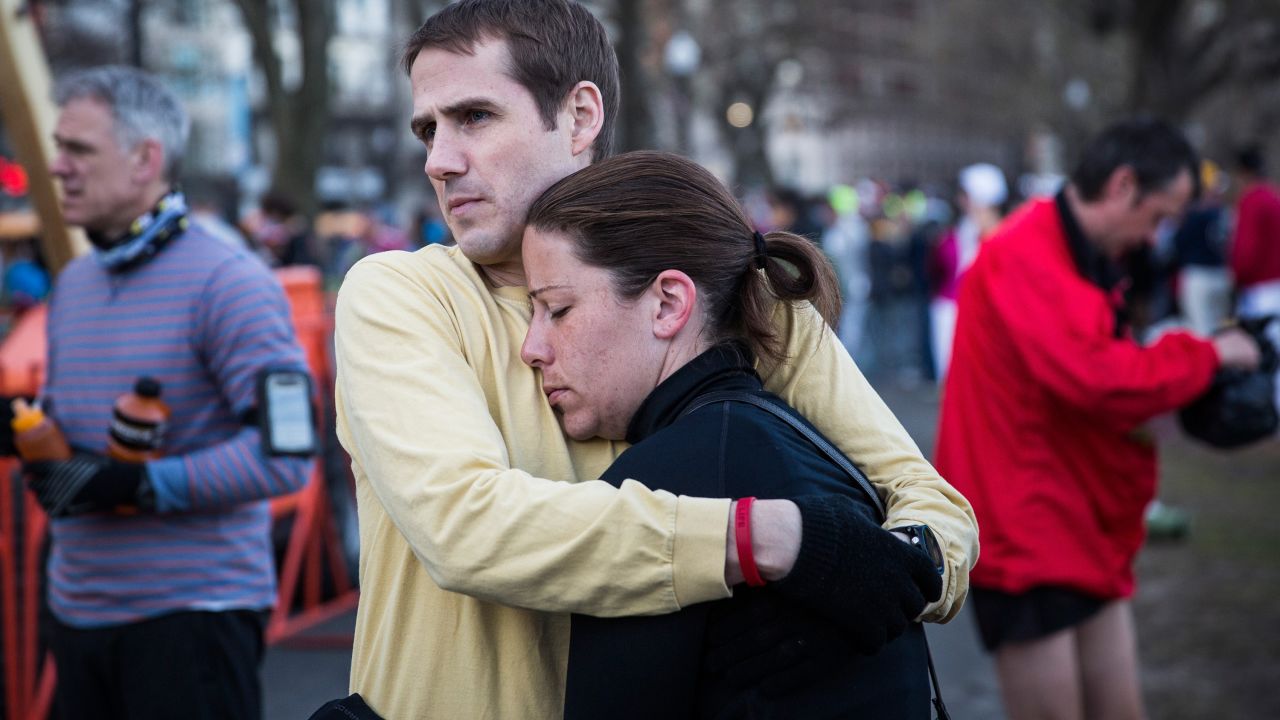 A couple waits for a bus to take them to the starting line on April 21.