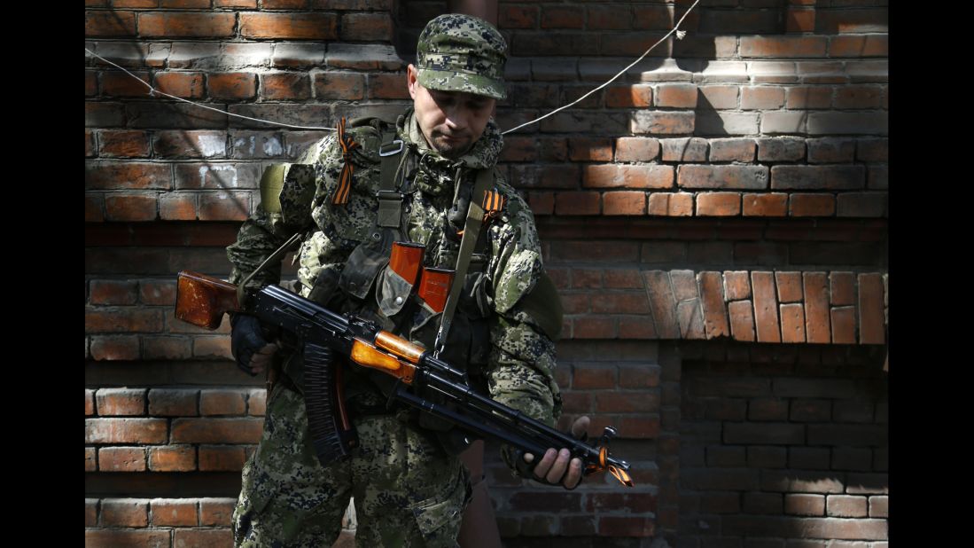 An armed pro-Russian man stands on a street in Slovyansk on Monday, April 21.