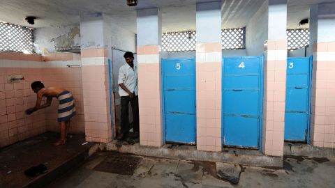File photo: A Indian man washes as another comes out of a toilet in a toilet complex run by an NGO Sulabh International at railway station in New Delhi in 2011.