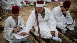 Members of the ancient Samaritan community read from a holy book during the pilgrimage for the holy day of Passover at the religion's holiest site on the top of Mount Gerizim near the West Bank town of Nablus, early Sunday, April 20, 2014. According to tradition, the Samaritans are descendants of Jews who were not deported when the Assyrians conquered Israel in the 8th century B.C. Of the small community of close to 700 people, half live in a village at Mount Gerizim, and Nablus and the rest in the city of Holon near Tel Aviv. (AP Photo/Ariel Schalit)