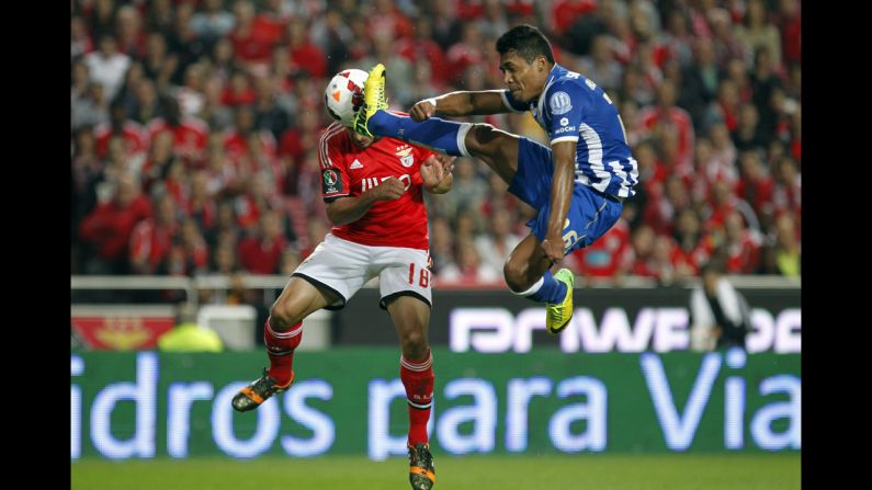 Benfica's Eduardo Salvio, left, heads the ball to score the opening goal past Porto's Alex Sandro during a Portugal Cup semifinal second leg soccer match in Lisbon on April 16.