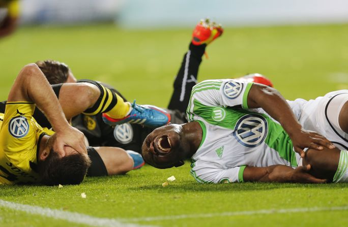 Dortmund's Sokratis, left, and Wolfsburg's Bernard Malanda-Adje lie injured during the German soccer cup semifinal match on April 15 in Dortmund, Germany.