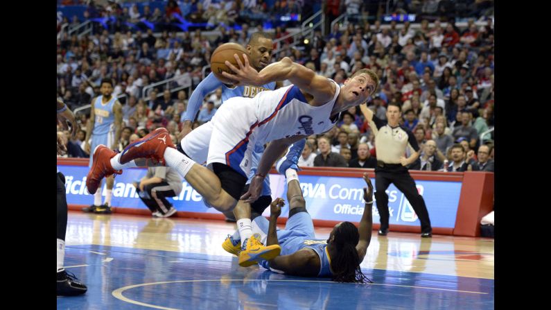 Los Angeles Clippers forward Blake Griffin passes the ball after colliding with Denver Nuggets forward Kenneth Faried during the second half on April 15 in Los Angeles. 