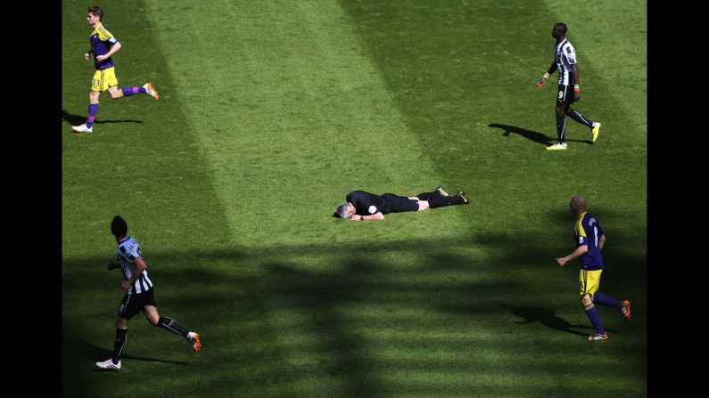 Referee Chris Foy, center, lies on the ground after being struck in the face by a reflected ball during the English Premier League soccer match between Newcastle United and Swansea City in Newcastle, England, on April 19.