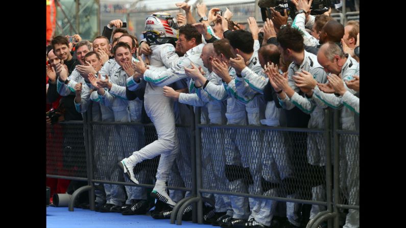 Great Britain's Lewis Hamilton celebrates his third straight Formula One victory with his team after the Chinese Formula One Grand Prix at the Shanghai International Circuit on April 20.