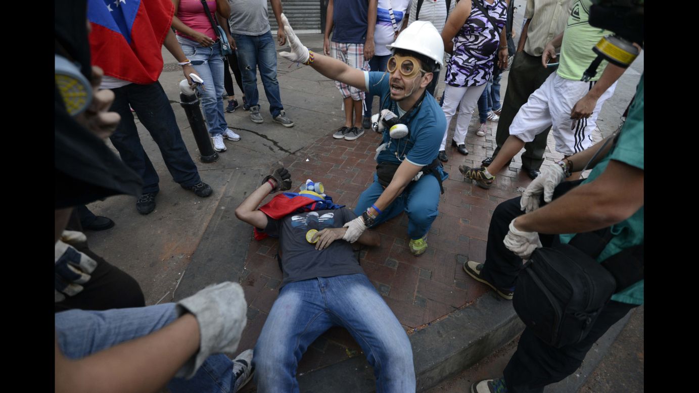 A man helps an injured demonstrator in Caracas on April 20.