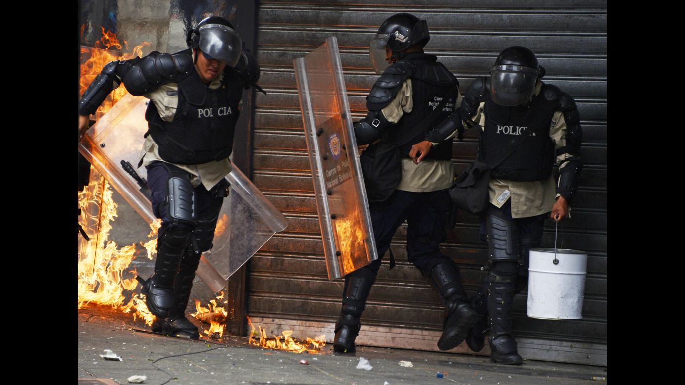 A police officer runs from a fire set off by a Molotov cocktail thrown by protesters in Caracas on April 17.