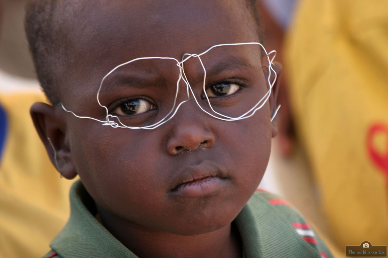 In "Creative Minds," five-year old Ken Kyalo wears a pair of glasses he fashioned from scrap wire during the laying of the foundation stone for a new building at the Heritage of Hope and Faith Children's Rehabilitation Center in Mlolongo, Kenya. 