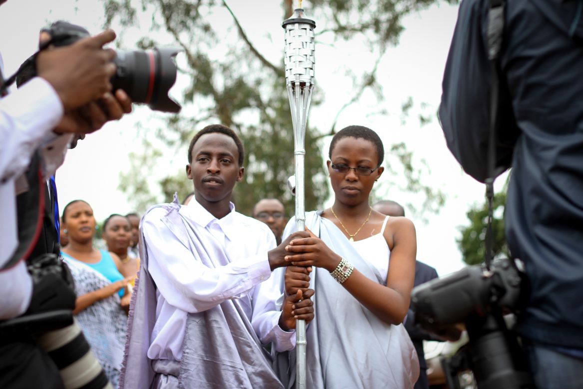 Jóvenes ruandeses portan la Llama del Recuerdo en el estadio IPRC en Kicukiro, el 5 de abril.