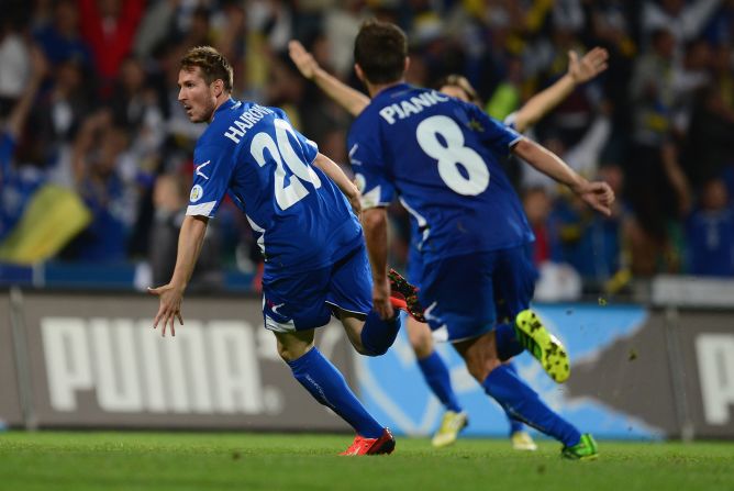 Izet Hajrovic (left) is chased by his teammates after scoring in the 78th minute. The Swiss-born player's sensational 30-yard strike sends Bosnian fans delirious. 