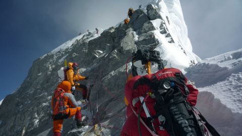 Mountaineers walk past the Hillary Step while pushing for the summit of Mount Everest as they climb the south face from Nepal, May 19, 2009.