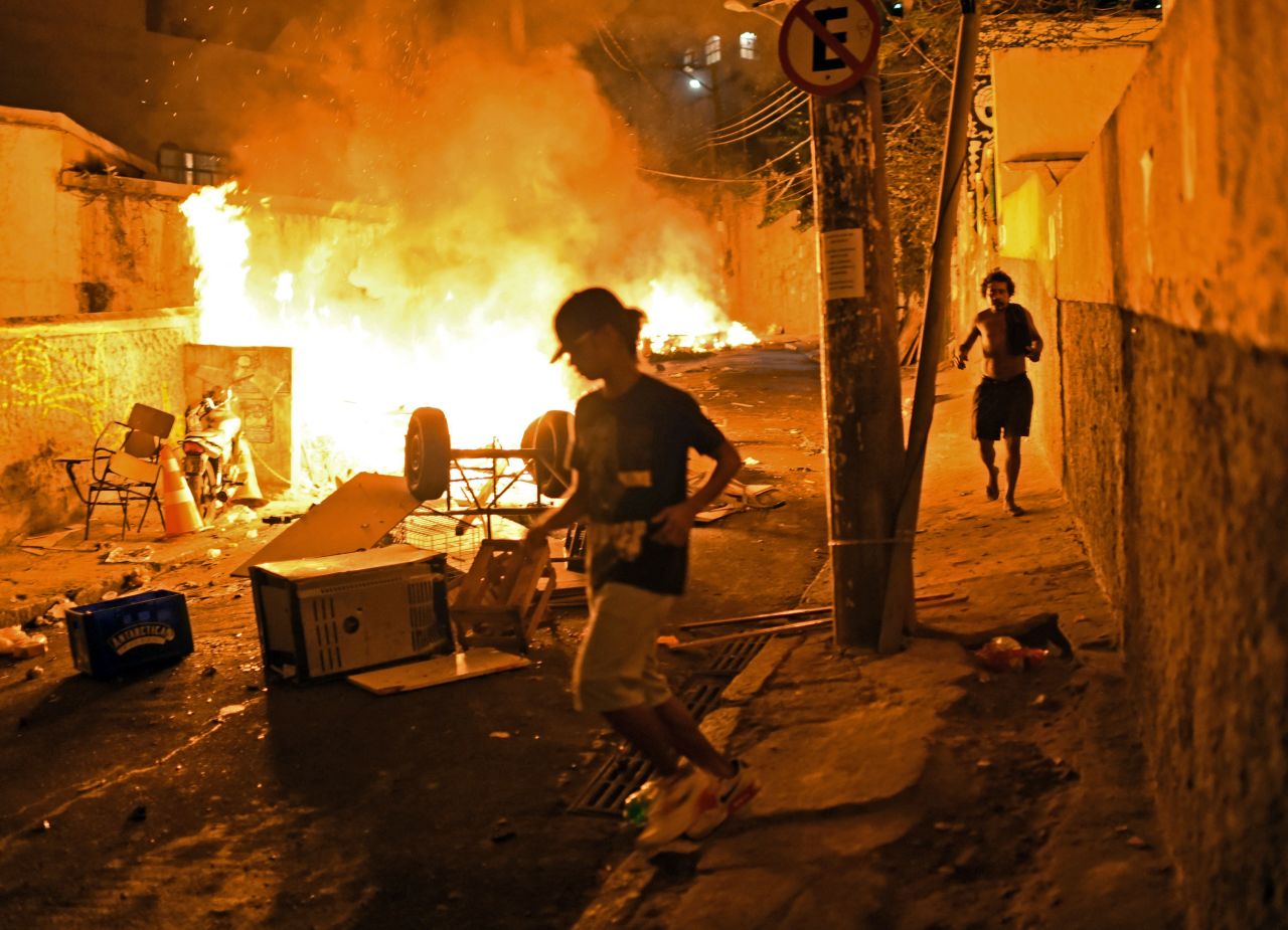 Residents run for cover during violent clashes between protesters and police.