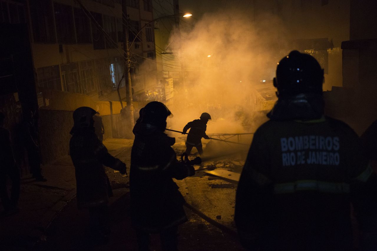 Firefighters put out a burning barricade during clashes.