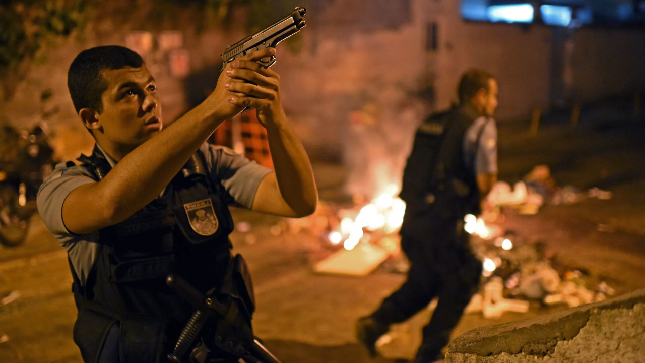 A police officer points his weapon during the protests.