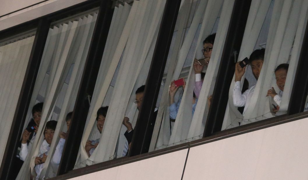 Office workers try to catch a glimpse of Obama as he and Japanese Prime Minister Shinzo Abe have dinner in Tokyo's Ginza District on Wednesday, April 23.