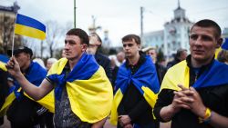 People draped in Ukrainian flags attend a pro-Ukrainian rally in the eastern Ukrainian city of Lugansk on April 19, 2014. 