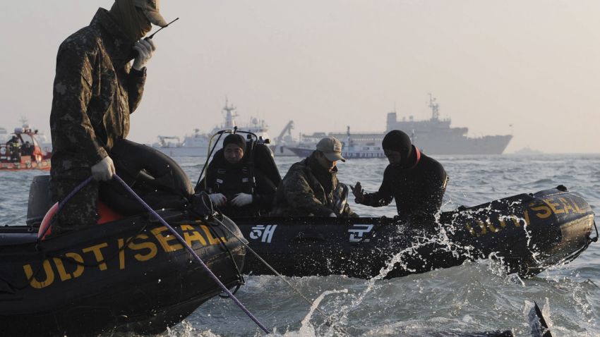 Divers look for people believed to have been trapped in the sunken ferry Sewol in the water off the southern coast near Jindo, south of Seoul, South Korea, Wednesday, April 23, 2014. The grim work of recovering bodies from the submerged South Korea ferry proceeded rapidly Wednesday, with the official death toll reaching over 140, though a government official said divers must now rip through cabin walls to retrieve more victims. (AP Photo/Yonhap) KOREA OUT