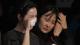 ANSAN, SOUTH KOREA - APRIL 23: South Korean mourners weep after tribute at a group memorial altar for victims of sunken passengers ship at the Ansan Olympic Memorial Hall on April 23, 2014 in Ansan, South Korea. At the altar, Friends and relatives are able to pay tribute to those who have passed in the April 16 ferry disaster off of Jindo Island in South Korea. The confirmed death toll now reached 130, and more than 170 people are still missing, as reported. (Photo by Chung Sung-Jun/Getty Images)