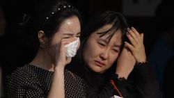 ANSAN, SOUTH KOREA - APRIL 23: South Korean mourners weep after tribute at a group memorial altar for victims of sunken passengers ship at the Ansan Olympic Memorial Hall on April 23, 2014 in Ansan, South Korea. At the altar, Friends and relatives are able to pay tribute to those who have passed in the April 16 ferry disaster off of Jindo Island in South Korea. The confirmed death toll now reached 130, and more than 170 people are still missing, as reported. (Photo by Chung Sung-Jun/Getty Images)