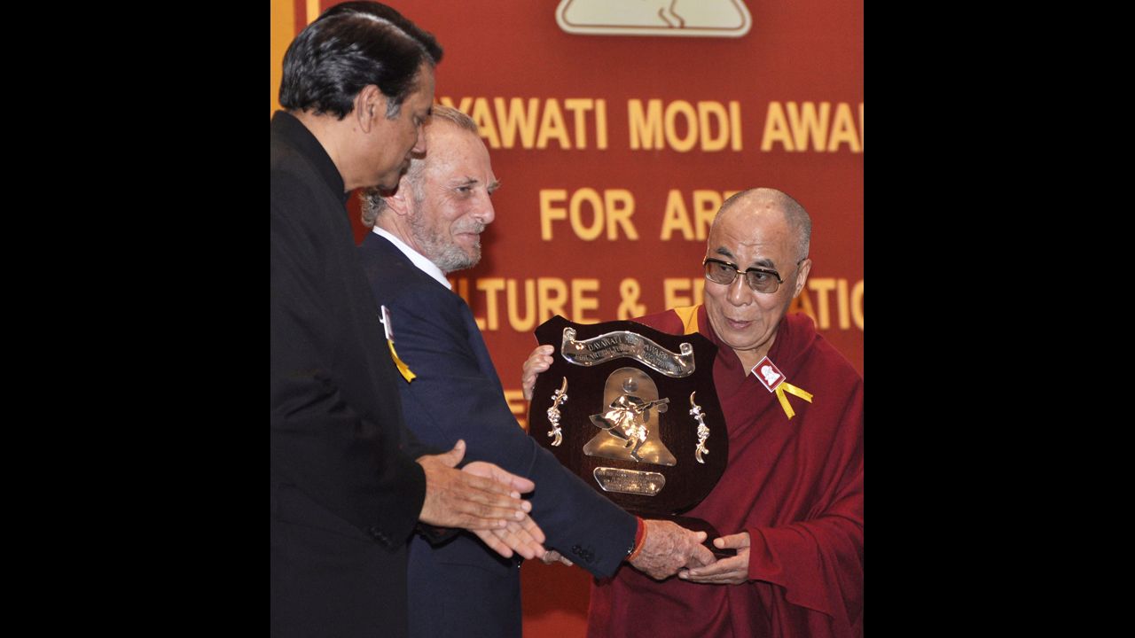 The Dalai Lama is presented with the Dayawati Modi Award for 2011 by Shand, center, in New Delhi on December 2, 2011. SK Modi, left, president of the Dayawati Modi Foundation, looks on. 