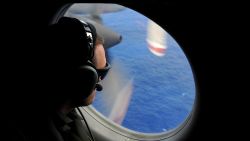 A crew member of a Royal New Zealand Airforce (RNZAF) P-3K2-Orion aircraft helps to look for objects during the search for missing Malaysia Airlines flight MH370 in flight over the Indian Ocean on April 13, 2014 off the coast of Perth, Australia. S
