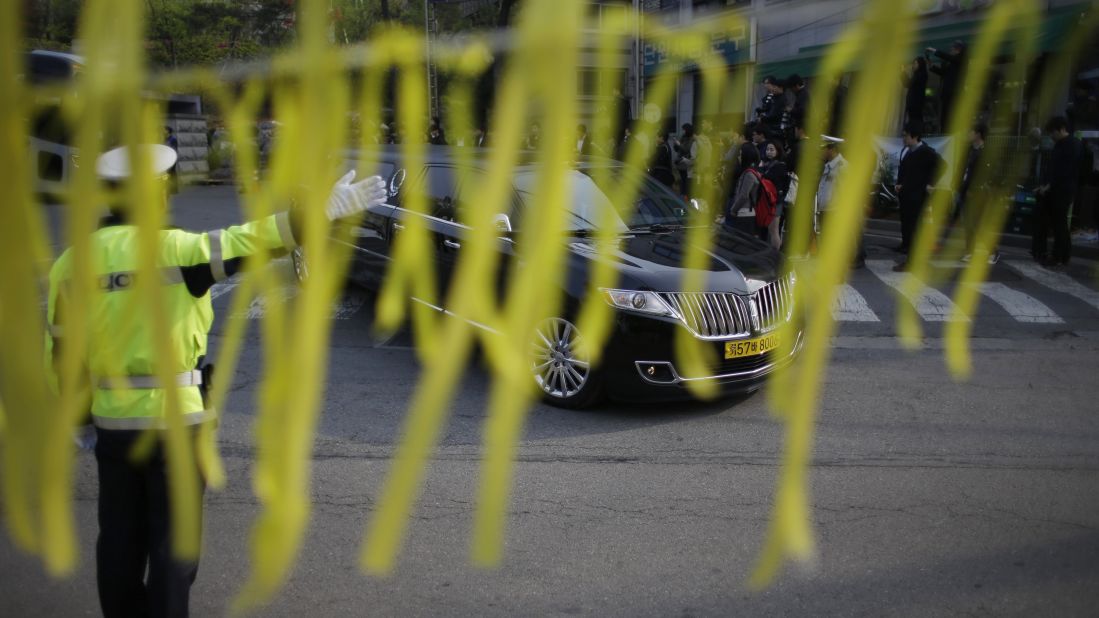 Yellow ribbons honoring the victims flap in the wind as a hearse carrying a victim's body leaves Danwon High School in Ansan on April 24. Most of the people on board the ferry were high school students on their way to the resort island of Jeju.