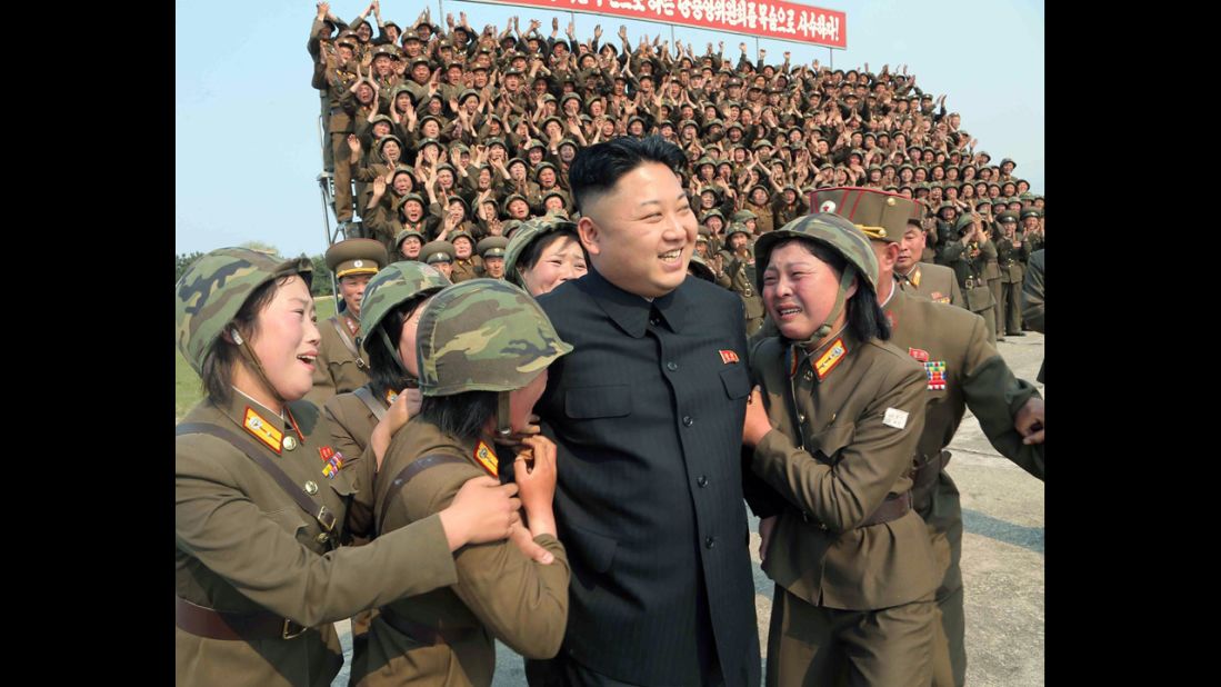 In this photo released Thursday, April 24, by the Korean Central News Agency, Kim smiles with female soldiers after inspecting a rocket-launching drill at an undisclosed location.